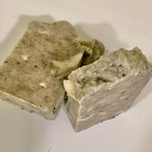 Two bars of natural soap on an off-white background. The herb coloring comes from the gotu-kola ingredient. It has a neutral scent.