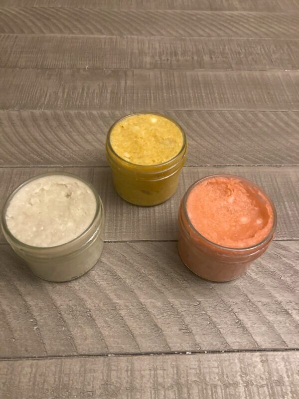 Three 4 oz glass jars filled with uniquely colored shaving soap.